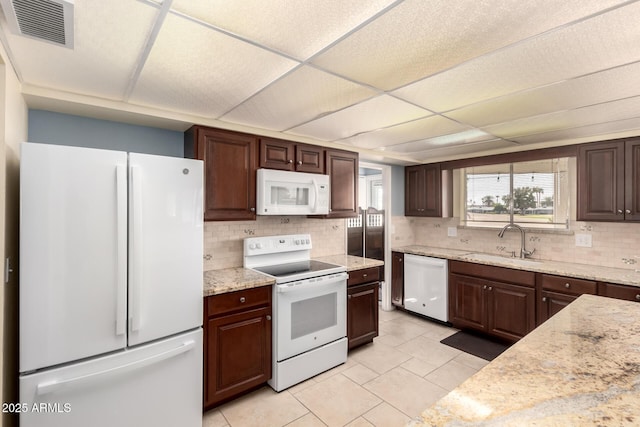 kitchen with a drop ceiling, white appliances, a sink, visible vents, and backsplash