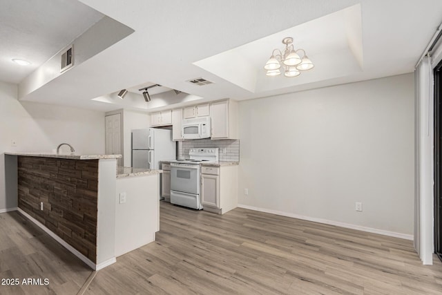 234 N 75th St Unit 209, Mesa, AZ 85207 - kitchen with white appliances, a raised ceiling, light wood-style flooring, baseboards, and light stone countertops