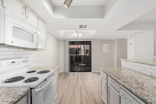 234 N 75th St Unit 209, Mesa, AZ 85207 - kitchen featuring white appliances, a tray ceiling, light wood-style floors, and decorative backsplash