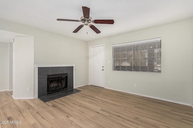 234 N 75th St Unit 209, Mesa, AZ 85207 - unfurnished living room with wood finished floors, ceiling fan, baseboards, and a tile fireplace