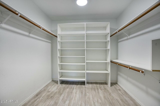 spacious closet with light hardwood / wood-style floors