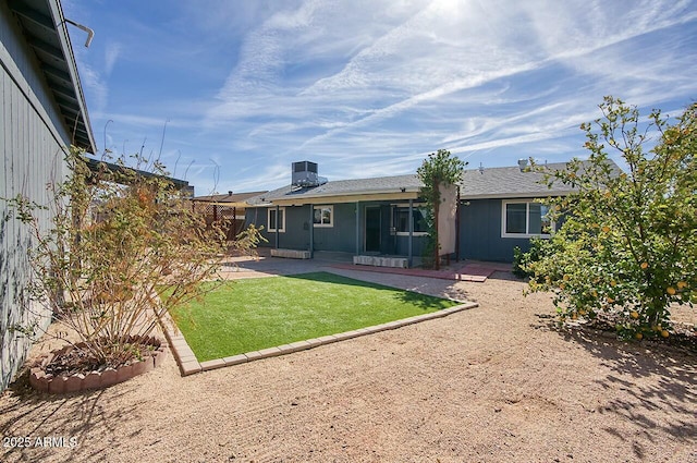 back of house featuring a lawn, central AC unit, and a patio area