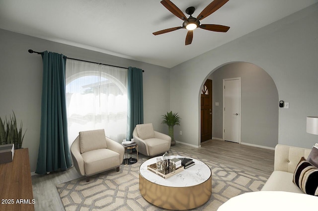 living room with ceiling fan, lofted ceiling, and light hardwood / wood-style flooring