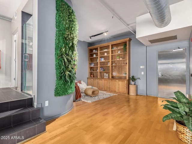 living area featuring track lighting and hardwood / wood-style flooring