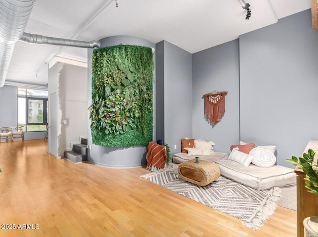 sitting room with track lighting and hardwood / wood-style flooring