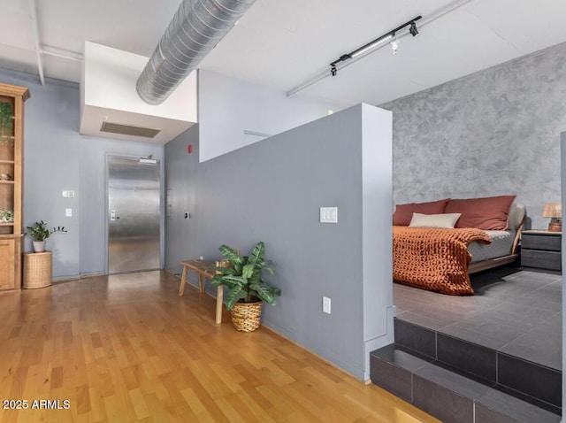 corridor with elevator and wood-type flooring