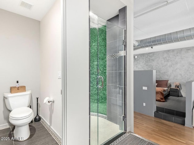 bathroom featuring a healthy amount of sunlight, toilet, a shower with shower door, and wood-type flooring