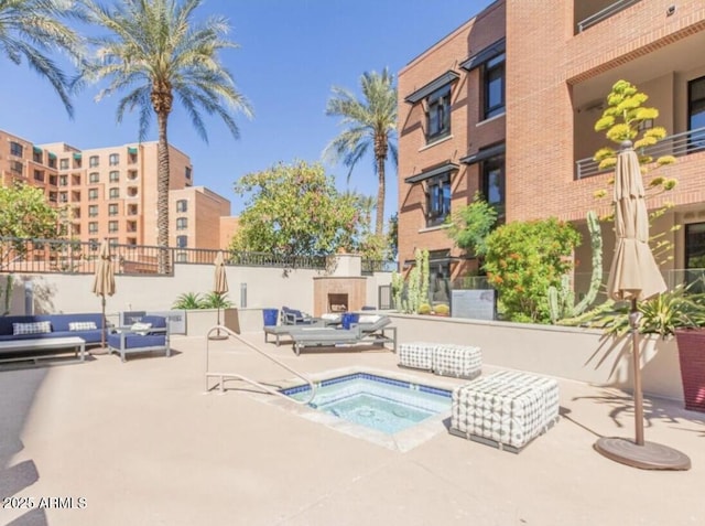 view of swimming pool with exterior fireplace, a community hot tub, and a patio