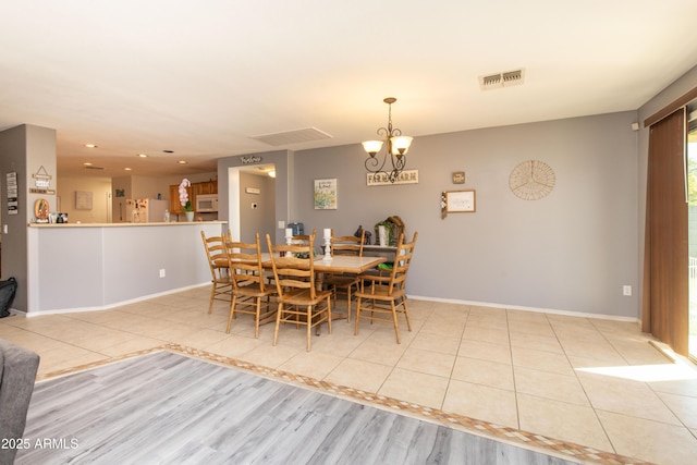 dining room with an inviting chandelier and light tile patterned floors