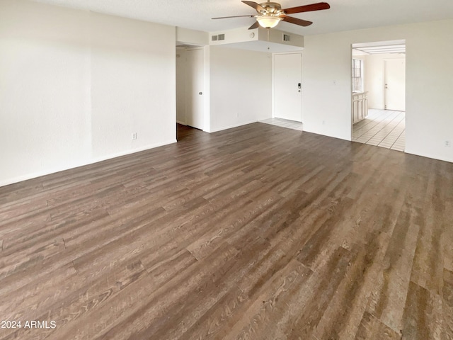 unfurnished room featuring ceiling fan, wood finished floors, and visible vents