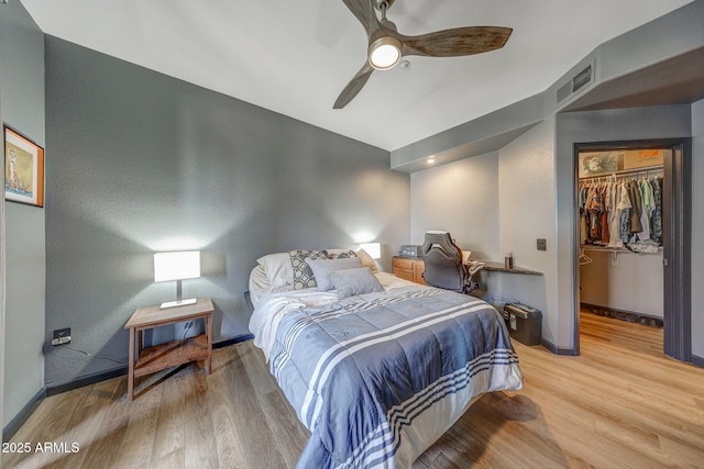 5303 N 7th St Unit 331, Phoenix, AZ 85014 - bedroom featuring wood finished floors, a spacious closet, ceiling fan, and a closet