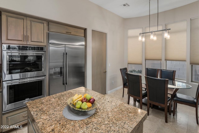 kitchen featuring light stone countertops, stainless steel appliances, and a kitchen island