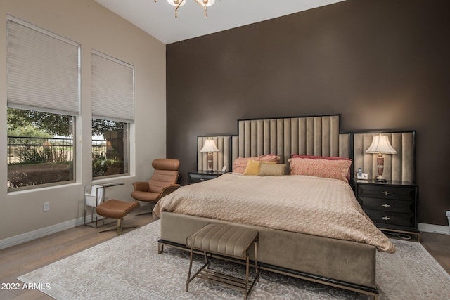 bedroom featuring a notable chandelier and dark wood-type flooring