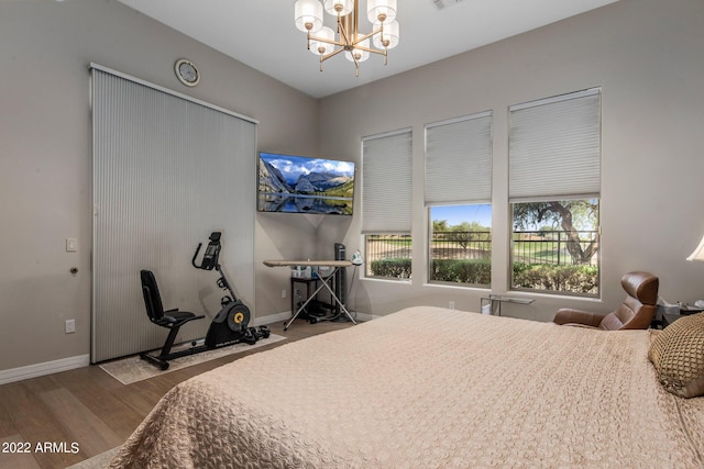 bedroom with a chandelier and hardwood / wood-style floors