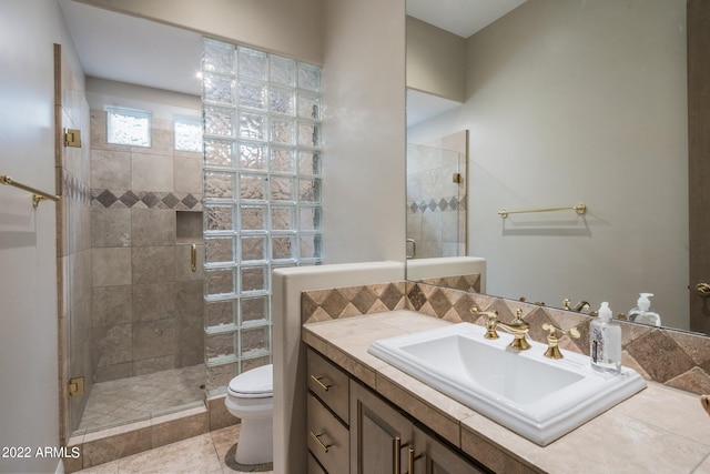 bathroom with tile floors, toilet, vanity, and a shower with shower door