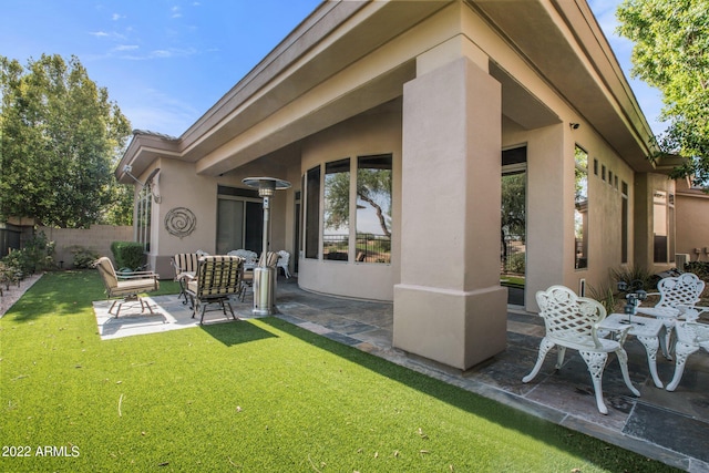 rear view of house featuring a lawn and a patio