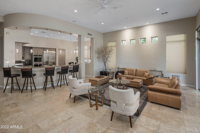 living room with light tile flooring, ceiling fan, and sink