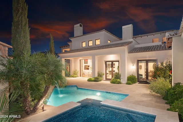 back of property with french doors, pool water feature, and a patio