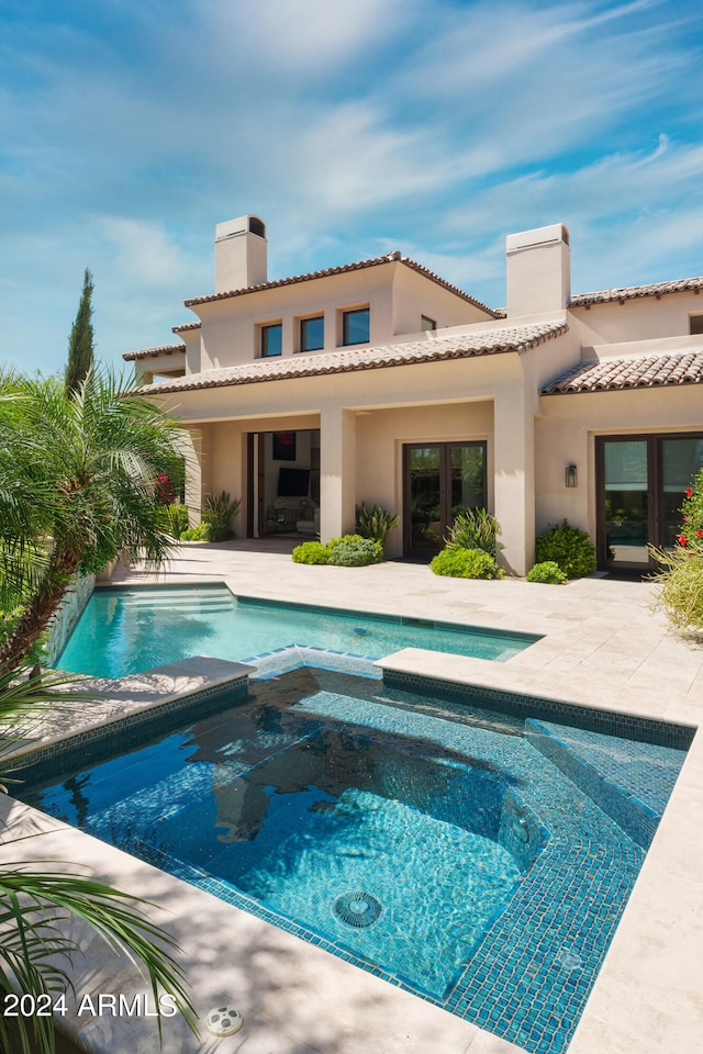 view of pool with a patio and an in ground hot tub