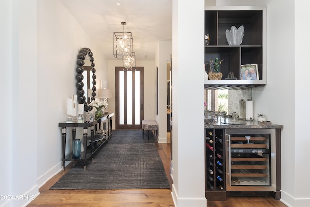 entryway with dark hardwood / wood-style floors and beverage cooler