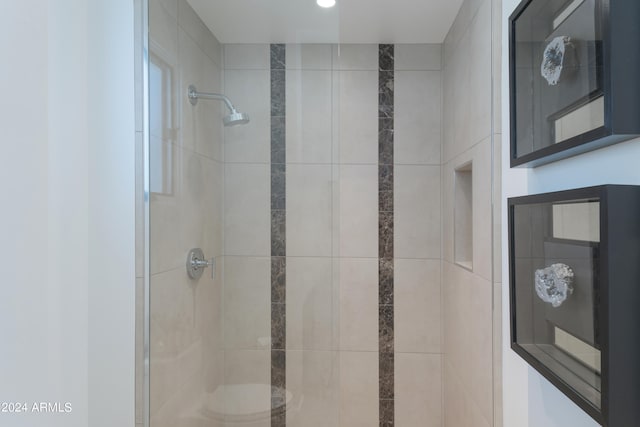 bathroom with toilet and a tile shower