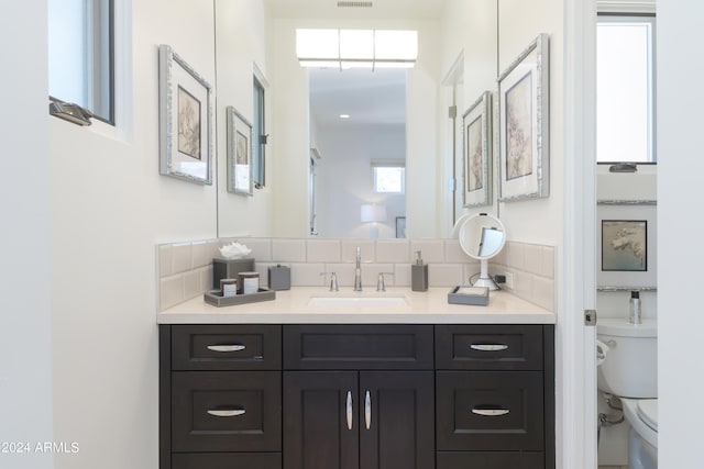 bathroom featuring backsplash, oversized vanity, and toilet