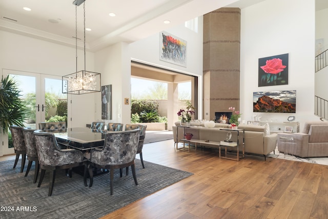 dining room featuring hardwood / wood-style flooring, a towering ceiling, and a wealth of natural light