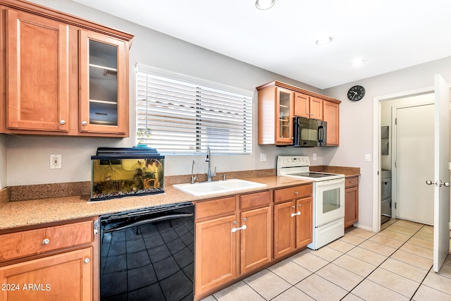 kitchen featuring black appliances, light tile patterned floors, and sink