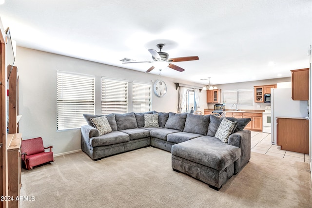 carpeted living room featuring ceiling fan, sink, and a wealth of natural light