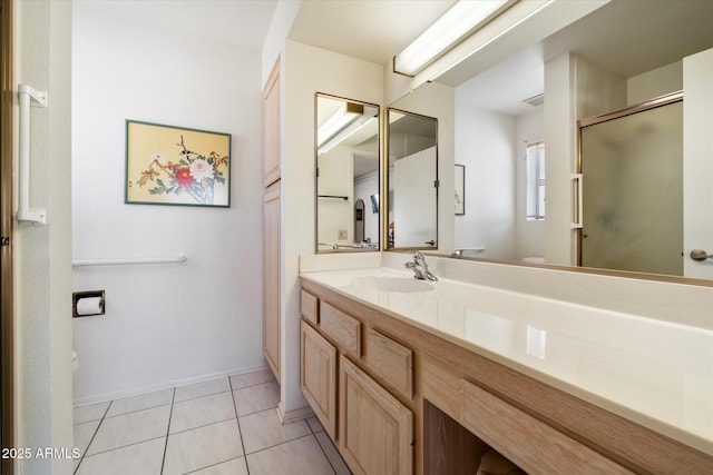 bathroom featuring baseboards, toilet, tile patterned flooring, vanity, and a shower stall