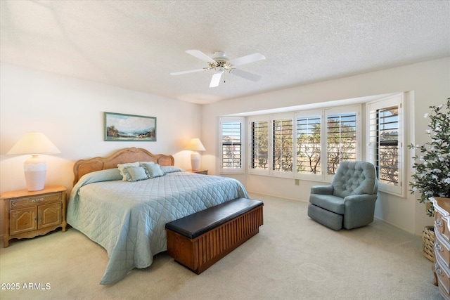 bedroom featuring light carpet, a ceiling fan, and a textured ceiling