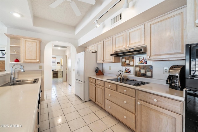 kitchen featuring visible vents, light brown cabinets, under cabinet range hood, and black electric cooktop