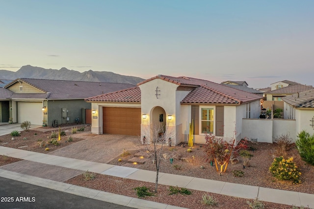 mediterranean / spanish-style house with a mountain view and a garage