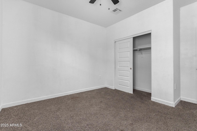 unfurnished bedroom with ceiling fan, a closet, and dark colored carpet