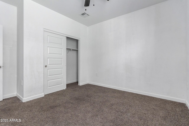 unfurnished bedroom with ceiling fan, a closet, and dark carpet