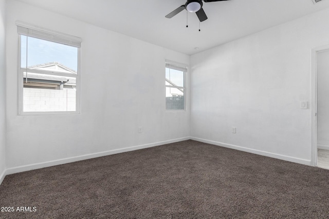 empty room featuring ceiling fan and dark carpet