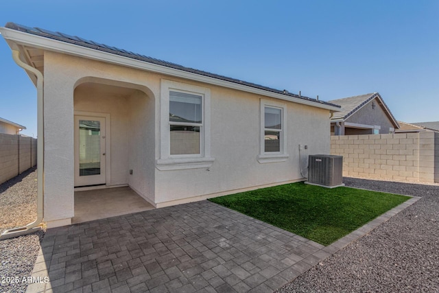 rear view of house with cooling unit and a patio