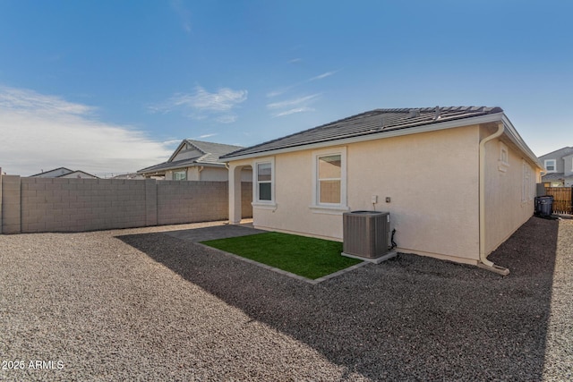 rear view of house featuring central AC unit and a patio