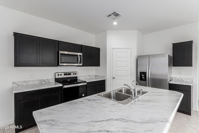 kitchen with appliances with stainless steel finishes, sink, and a center island with sink