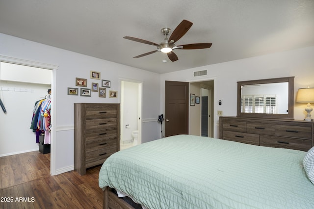 bedroom with a walk in closet, ensuite bath, dark hardwood / wood-style floors, a closet, and ceiling fan