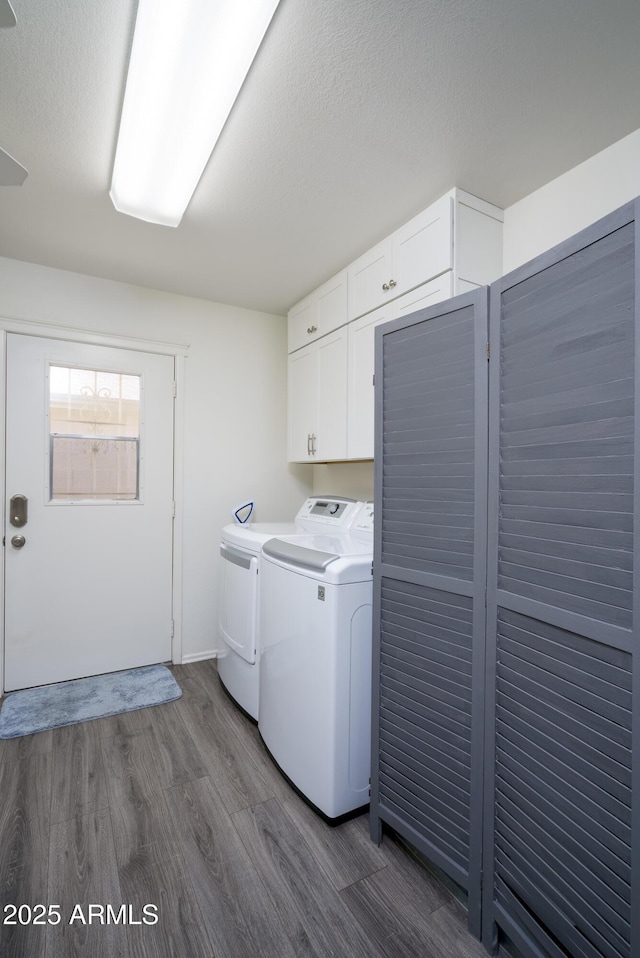 washroom featuring separate washer and dryer, dark wood-type flooring, cabinets, and a textured ceiling