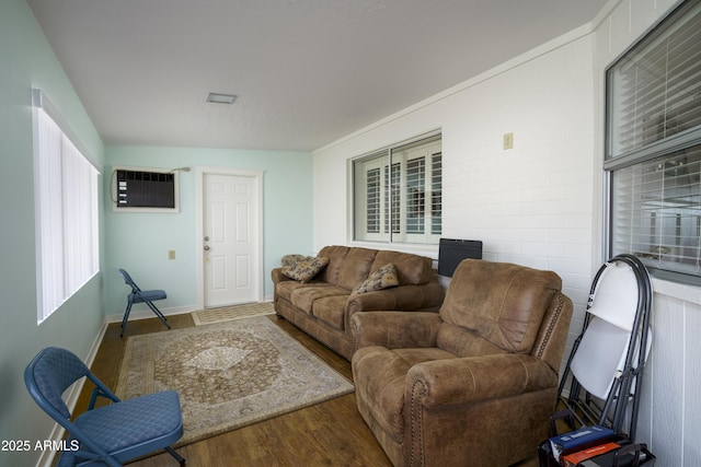 living room with a wall mounted air conditioner and wood-type flooring