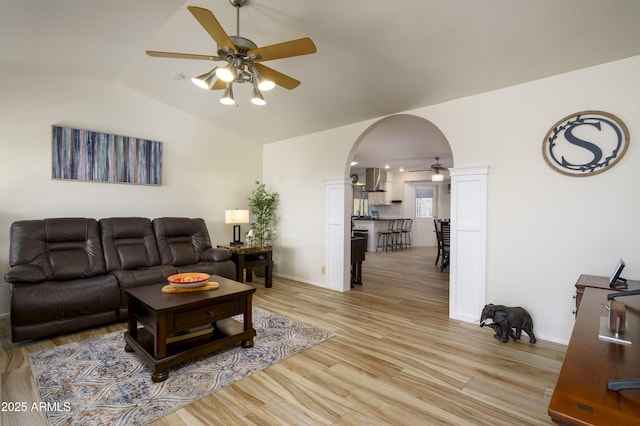 living room featuring ceiling fan, vaulted ceiling, and light hardwood / wood-style flooring