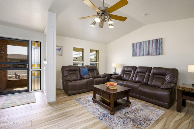 living room with ceiling fan, vaulted ceiling, and light hardwood / wood-style flooring