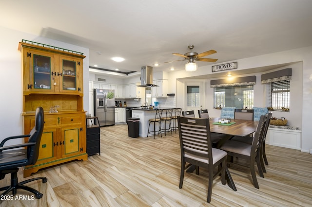 dining area featuring ceiling fan, sink, and light hardwood / wood-style floors