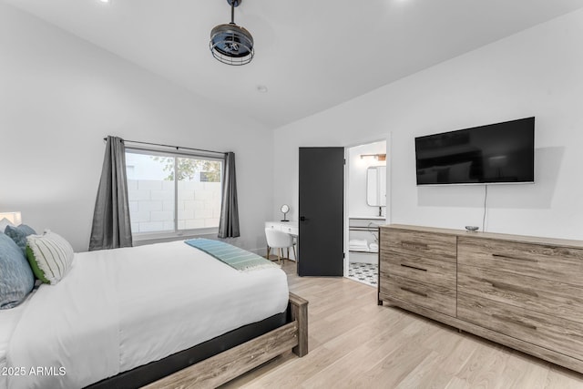 bedroom featuring lofted ceiling, ensuite bathroom, and light wood-type flooring