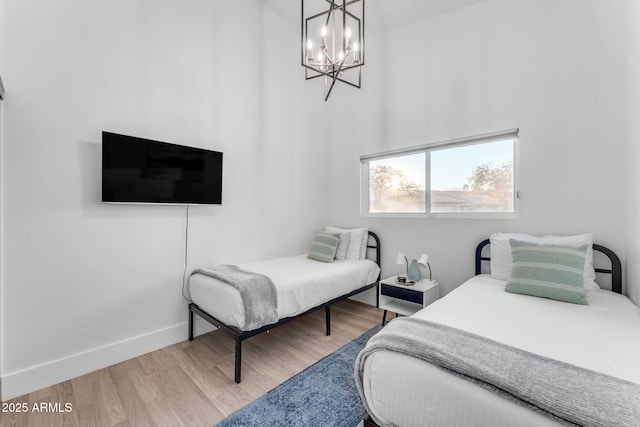 bedroom featuring a notable chandelier and light hardwood / wood-style flooring