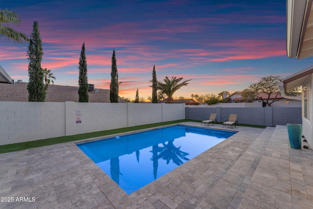 pool at dusk featuring a patio area