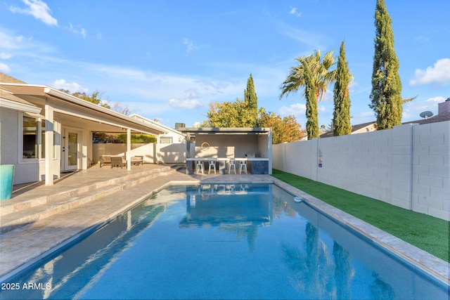 view of swimming pool featuring exterior bar and a patio area