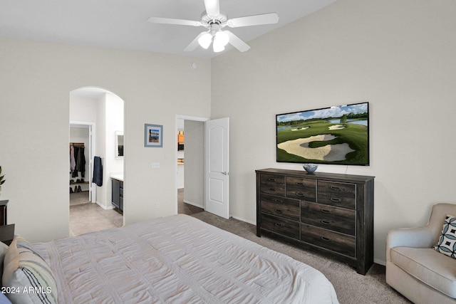 bedroom featuring light colored carpet, ensuite bath, and ceiling fan